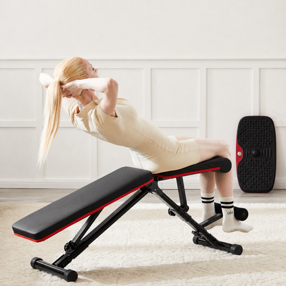 Woman doing sit-ups on the folding weight bench in decline position