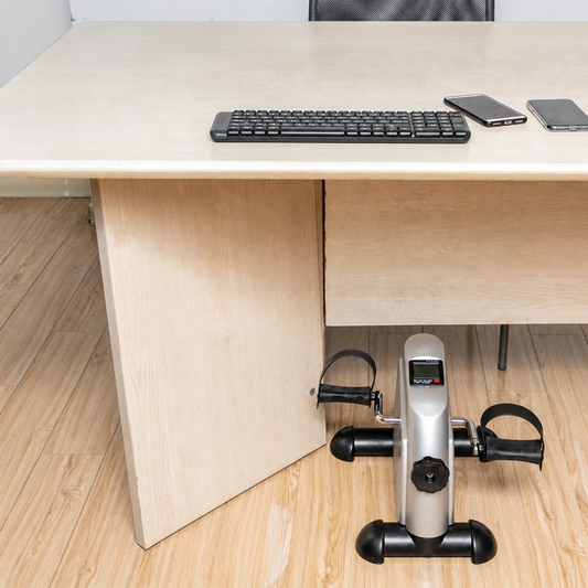 Mini pedal exerciser placed under a desk